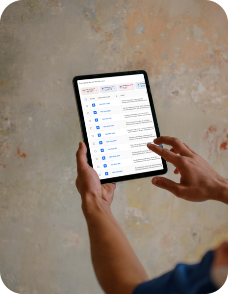 A person holding and interacting with a tablet displaying a list of items against a textured background.